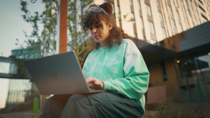 年轻的白人女程序员在科技创业公司后院使用笔记本电脑工作。专业女性在创新型公司编写代码和创建Web应用