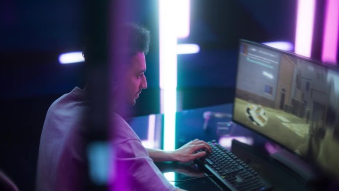 年轻玩家在赛博朋克数字霓虹灯世界的电脑上玩在线视频游戏。穿着时尚休闲服装的男性在互联网上播放射击游戏