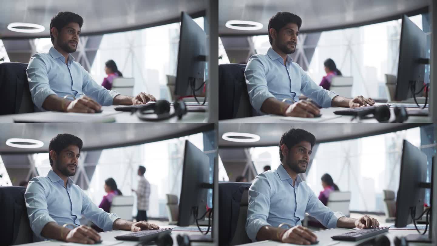一个南亚金融证券交易员在现代办公室的台式电脑上工作的肖像。英俊的印度会计簿记企业财务事务
