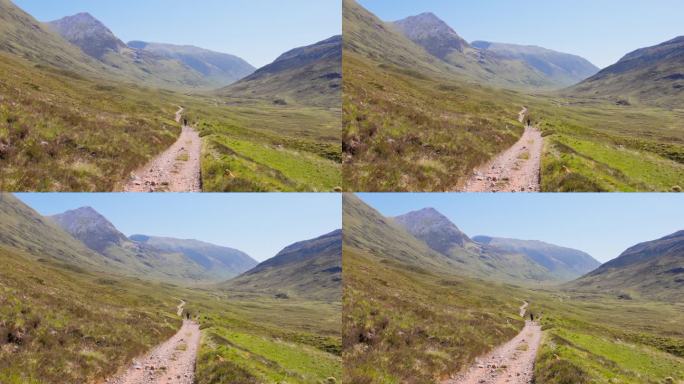 西高地徒步小径延伸到远处，郁郁葱葱的绿草，万里无云的天空，连绵起伏的丘陵，苏格兰