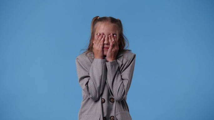 4k视频的女孩与狡猾的面部表情在蓝色背景。