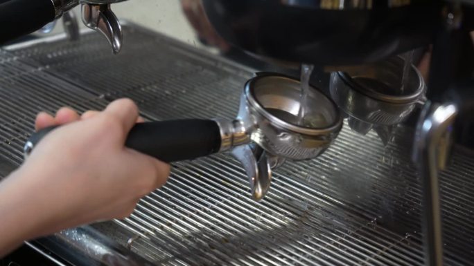 用捣碎的新鲜咖啡制备咖啡粉。捣碎现磨咖啡。咖啡师的手握着研磨好的咖啡粉，将其放入咖啡机中，准备冲一杯
