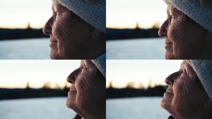 一位老年妇女在冬日的黄昏享受着新鲜的空气。