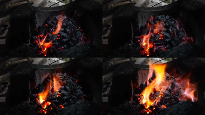 木柴在火中燃烧，木炭在炉子中燃烧。热炉子上燃烧的煤的特写。烧红的，滋滋作响的煤。
