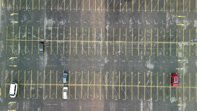 空旷的大停车场，无人机从上向下拍摄向前飞