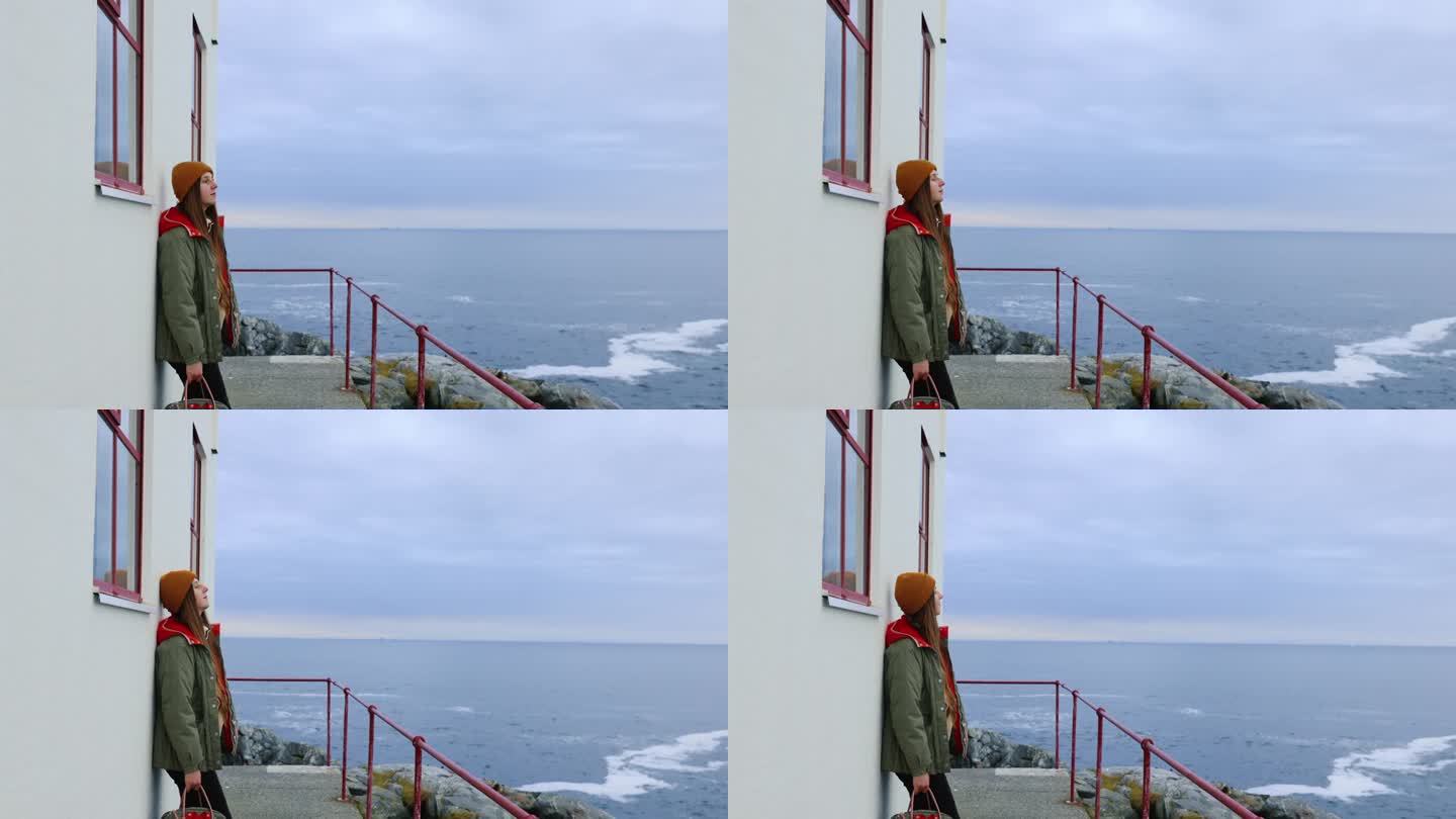 一名女子在挪威的灯塔边眺望海景
