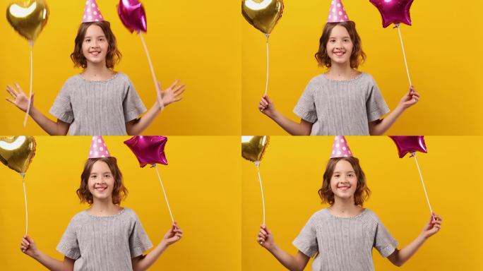 快乐，积极的十岁生日女孩戴着派对帽和气球