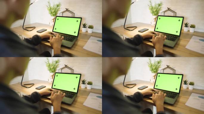 绿屏笔记本电脑，笔记本电脑站在家里的木桌上