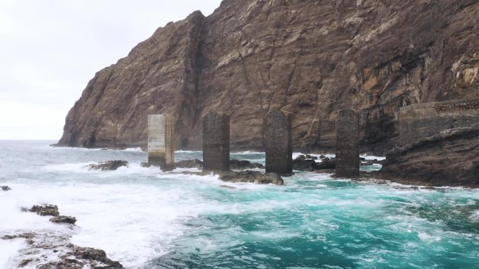 航拍中心照片，海浪冲击着具有古老结构的岩石