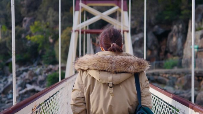 一个女人徒步穿过一座吊桥