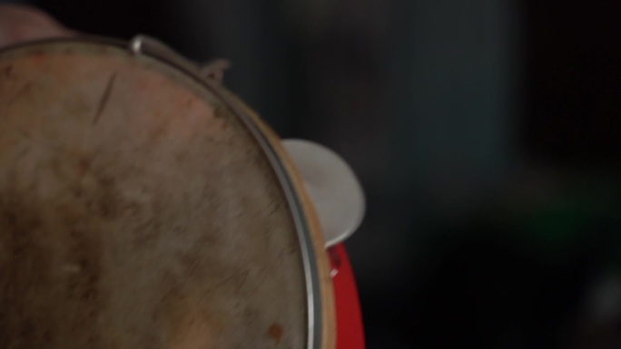 一个有脏膜和红边的旧手鼓，特写。检查手鼓的健康状况