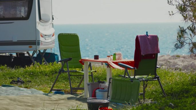 在海边露营。夏季在野外房车上的桌椅