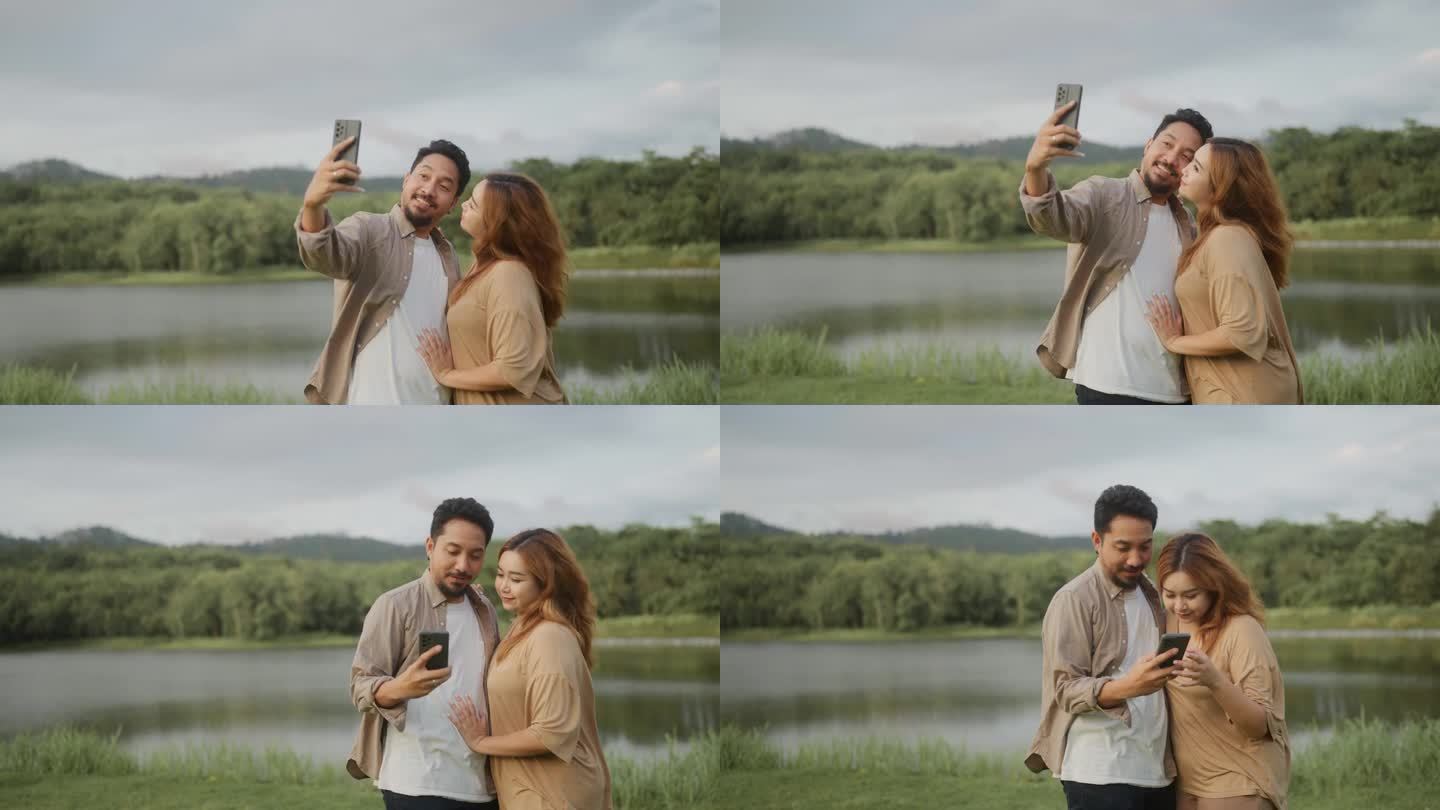 幸福的亚洲夫妇在湖边散步，用智能手机自拍度假。