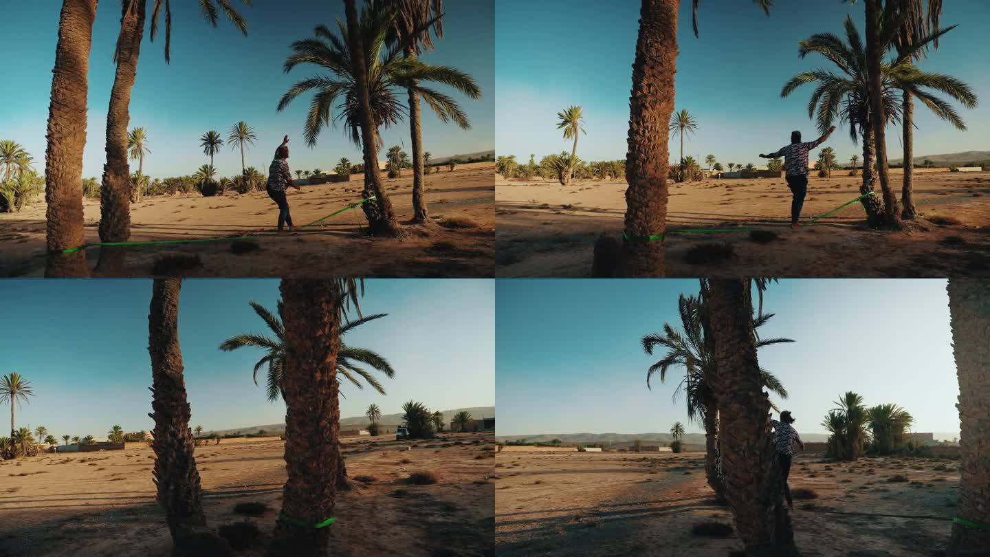 摩洛哥海滩上，一名男性游客在棕榈树间走钢丝