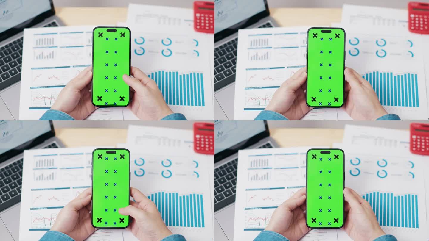 商人在办公室用绿屏色度键智能手机
