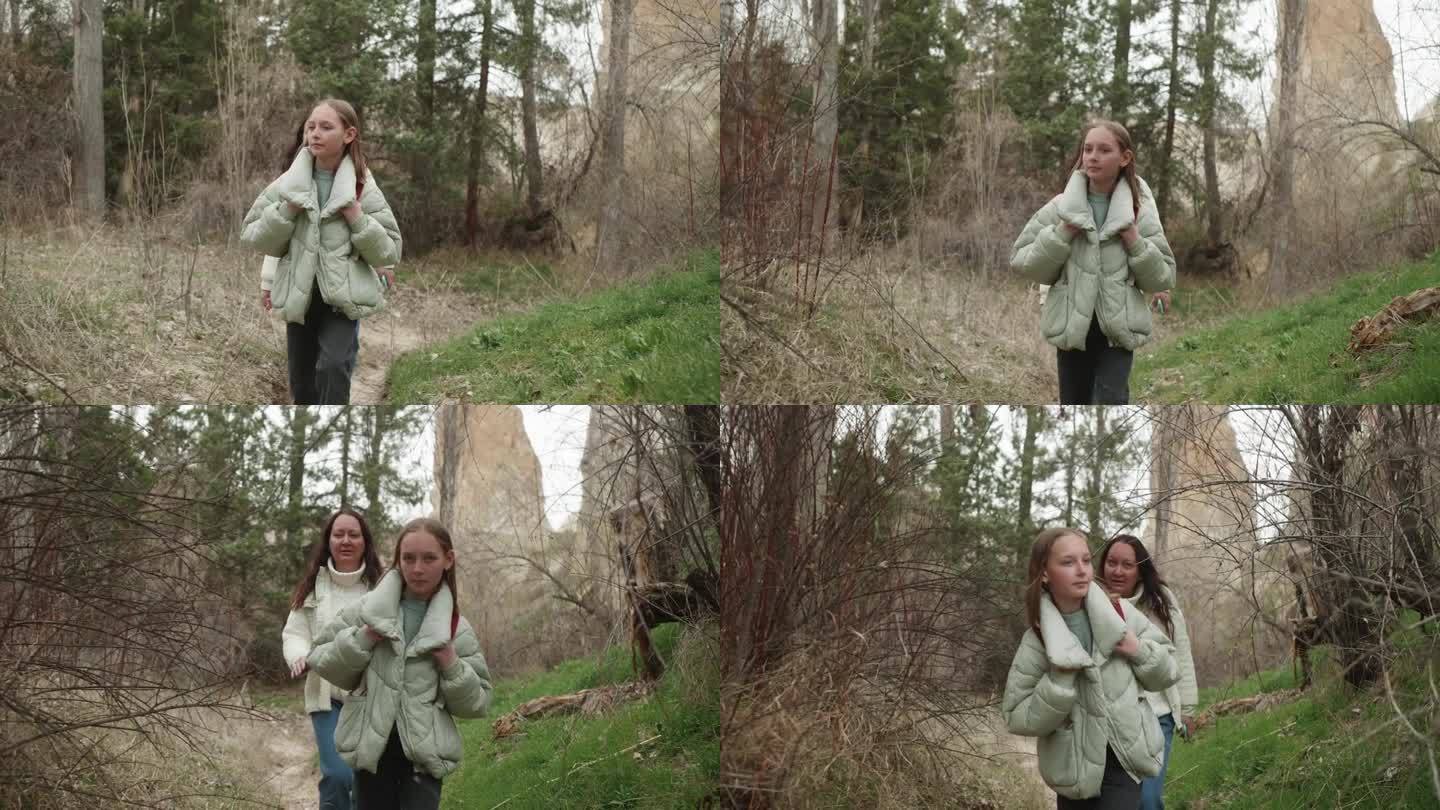 妈妈带着十几岁的女儿一起在春天的森林里散步，慢悠悠。