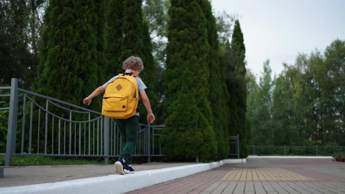 小学放学后走路的小男孩，背书包的小男孩的后视图