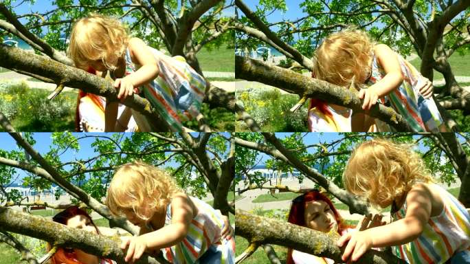 母亲扶着正在爬树的小女儿