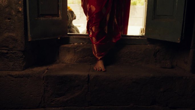 慢动作特写:一位印度妇女走进一座古庙。虔诚的女性穿着美丽的红色纱丽走进她的礼拜场所，寻求指导和智慧
