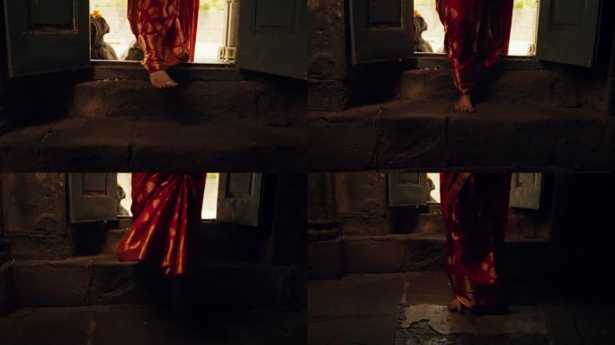 慢动作特写:一位印度妇女走进一座古庙。虔诚的女性穿着美丽的红色纱丽走进她的礼拜场所，寻求指导和智慧