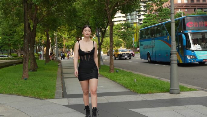 视频一个有吸引力的年轻女子在时尚的背装在城市