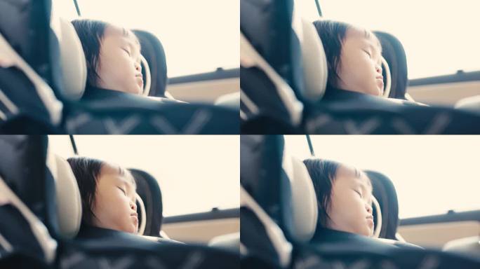 当家人在路上时，亚洲小孩睡在汽车座椅上