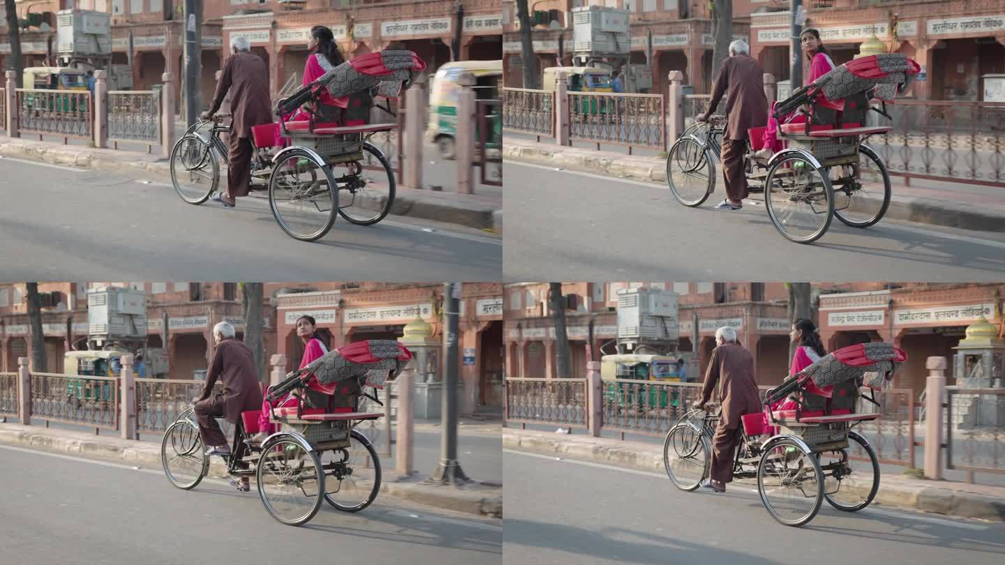 斋浦尔，一名印度男子和一名年轻女子骑着黄包车