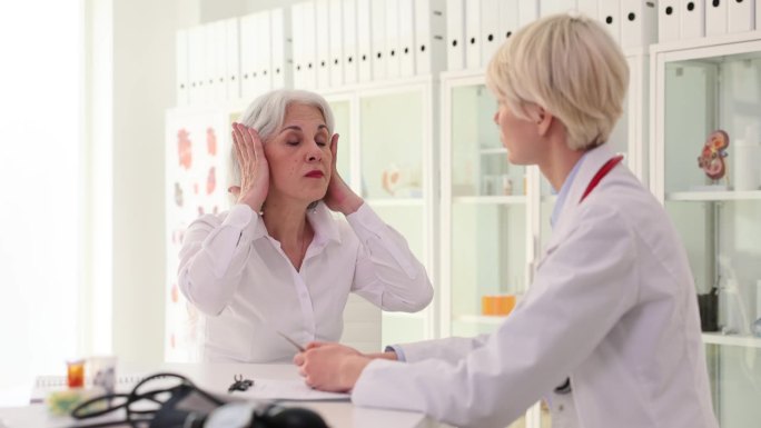 老年妇女和医生进行听力测试