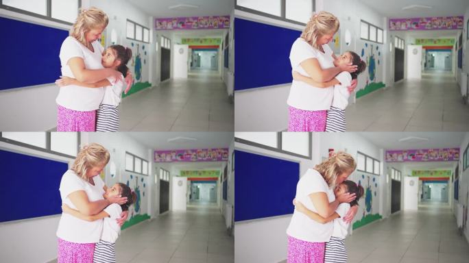 快乐的学生在学校走廊拥抱他的老师