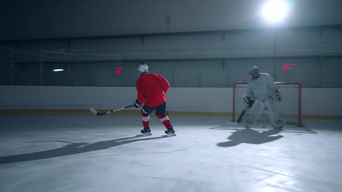 职业冰球运动员熟练地用冰球棒击球，在一个有着电影般的灯光的舞台上，在一个戏剧性的广角镜头中得分