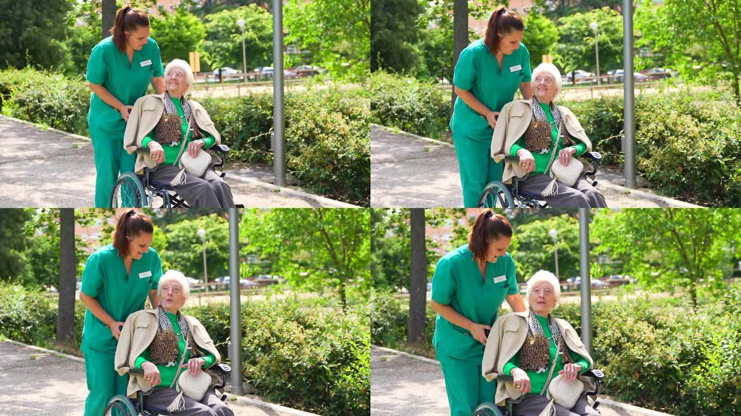 一位老年妇女和护士坐在轮椅上在养老院的花园里散步，旁边是大自然