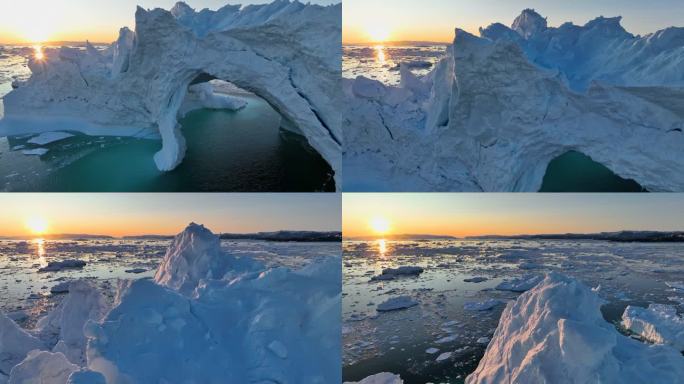 落日的鸟瞰图穿透冰山的边缘。日落时的冰山和冰洞。冰川融化，全球变暖，北极自然景观