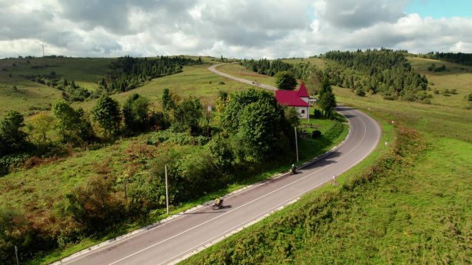 一个骑摩托车的人在晴朗的日子里骑在乡间平坦的道路上
