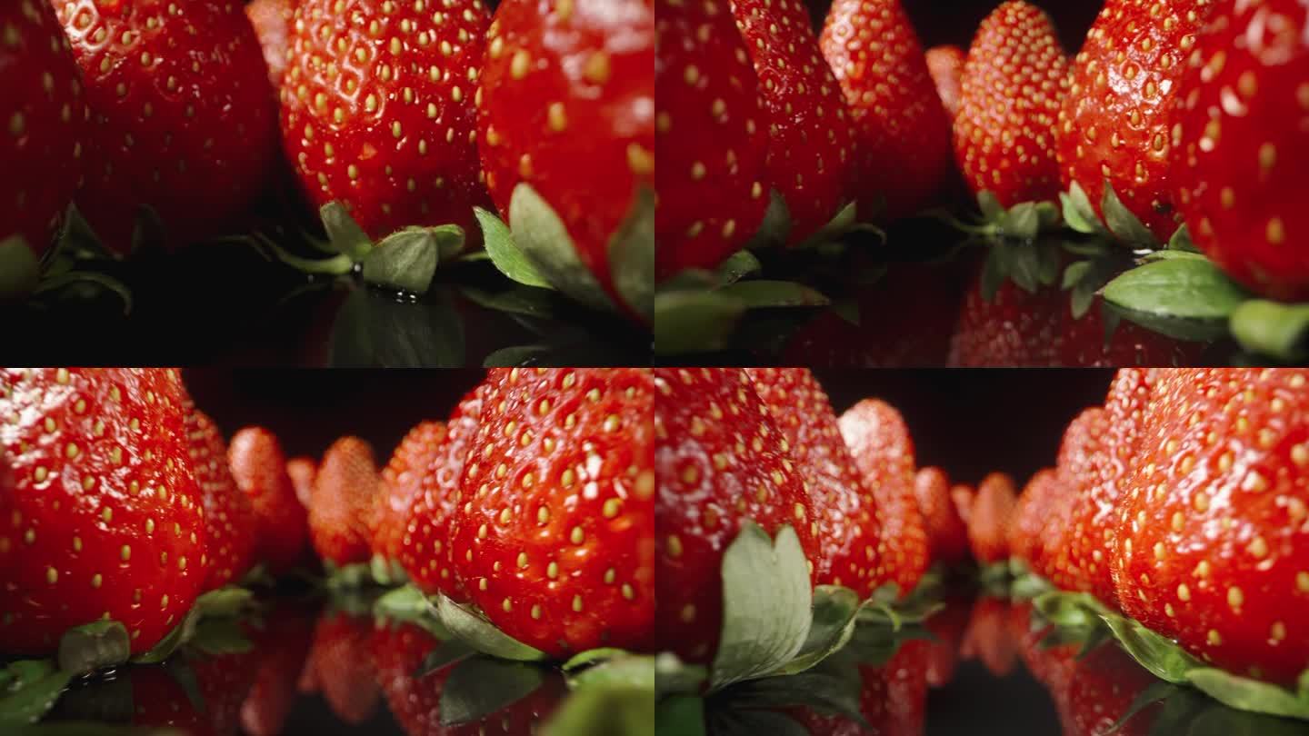 多汁的草莓整齐地摆放在带镜子的黑桌子上。多莉滑块极端特写。
