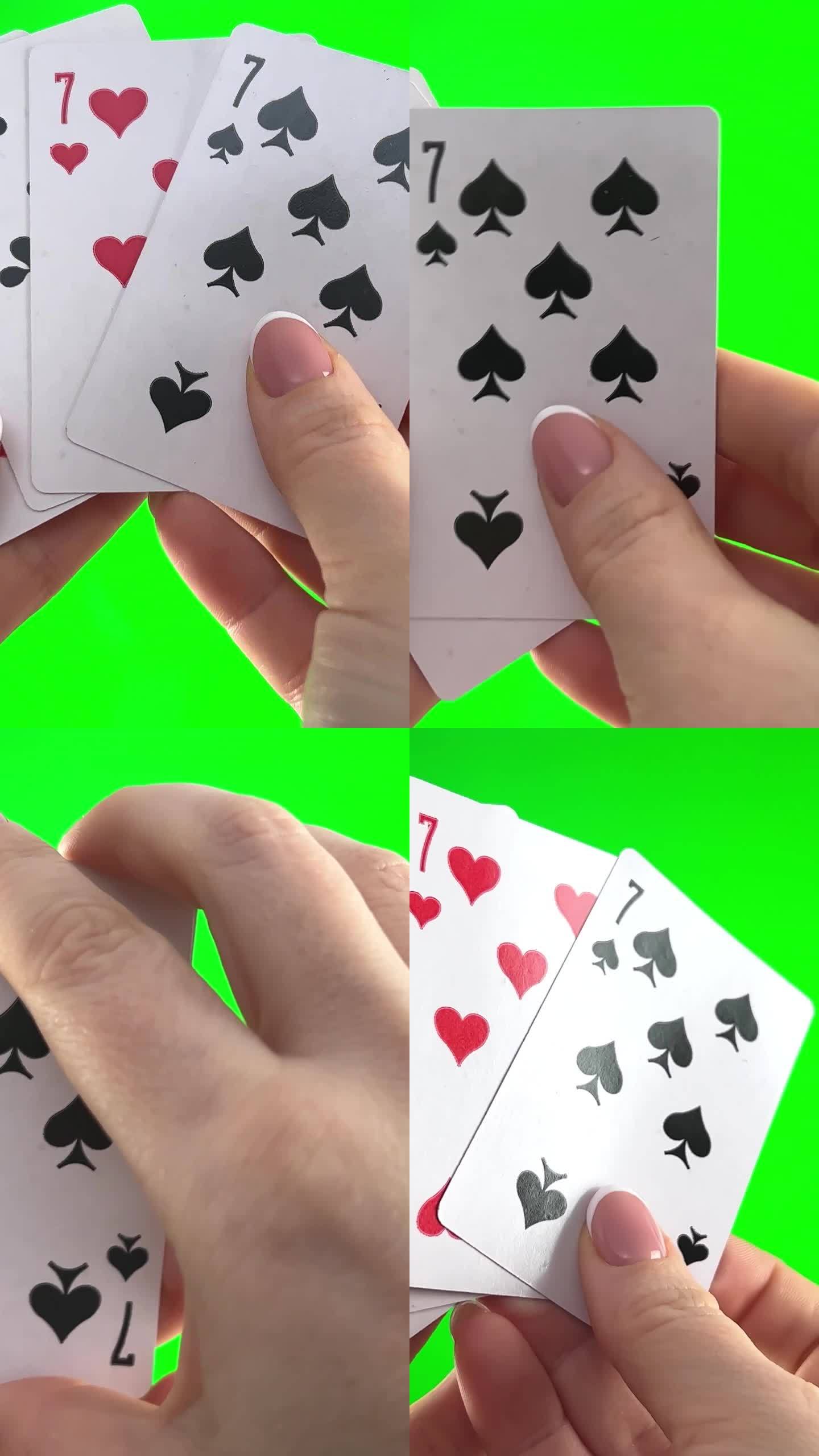 女性的手，法式美甲。女人整理卡片，检查它们，折叠起来，像扇子一样展开四张牌，同样的西装手拿着四张七，