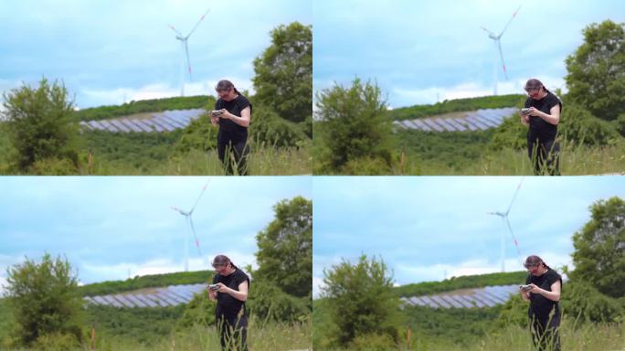 一名妇女在风力涡轮机旁使用遥控器