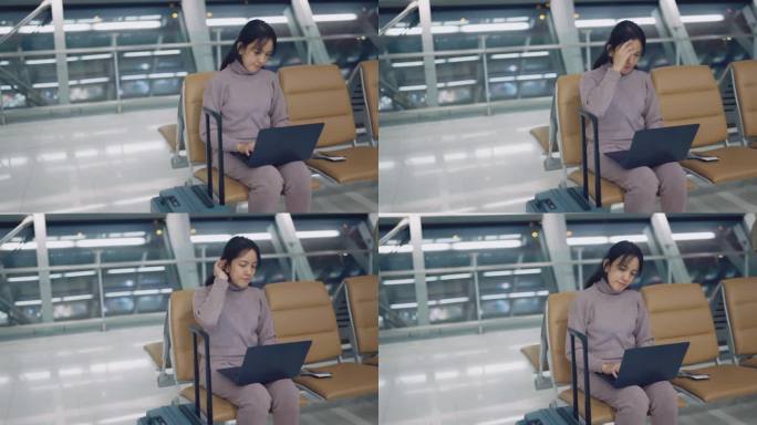 亚洲妇女坐在机场出发区，打开笔记本电脑，搜索有关她目的地的其他信息。