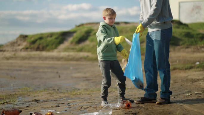 环保意识，成人和儿童从河岸收集垃圾，爱护生态