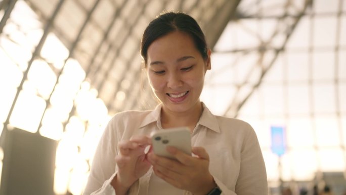亚洲女性在机场使用智能手机