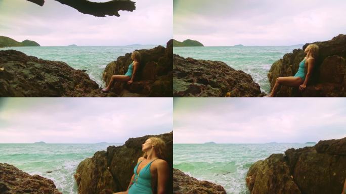 女人冥想，放松在岩石裂缝礁山在暴风雨的早晨多云的大海。概念女性化，性阴道健康，女性化，自由，新鲜