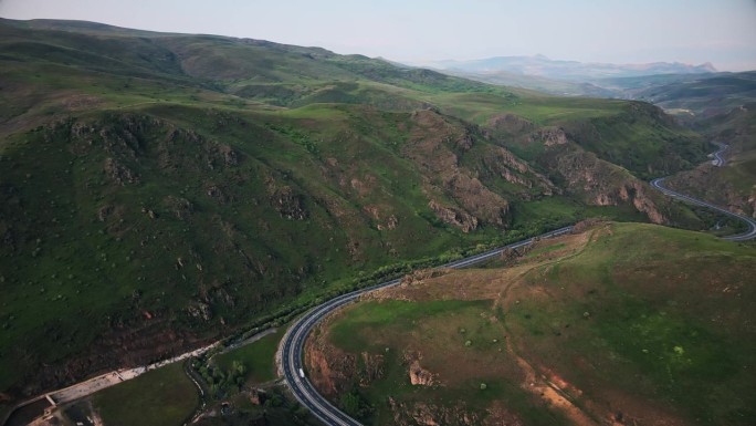 蜿蜒的道路在美丽的田野和山脉。无人机航拍图