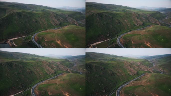 蜿蜒的道路在美丽的田野和山脉。无人机航拍图