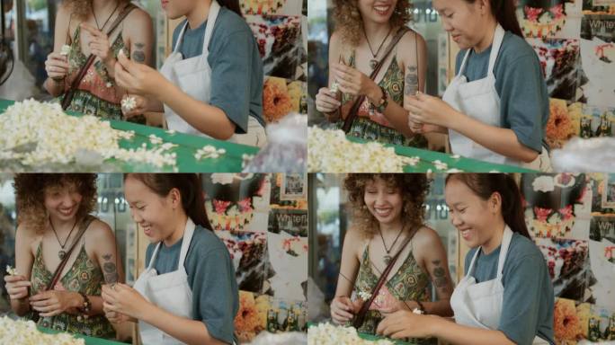 一位女游客在泰国学习泰国文化，如何制作花环。