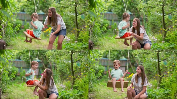 幸福的一家人，妈妈和孩子在花园里的树下荡秋千。幸福家庭的概念，梦想，娱乐。妈妈和儿子在一起