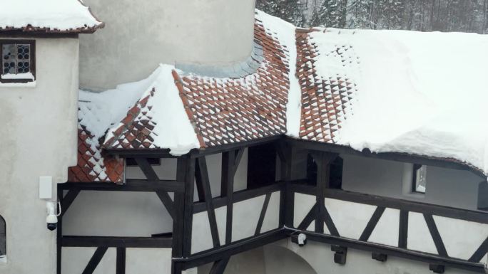 在暴风雪中，雪从中世纪城堡的红色屋顶上吹下来。