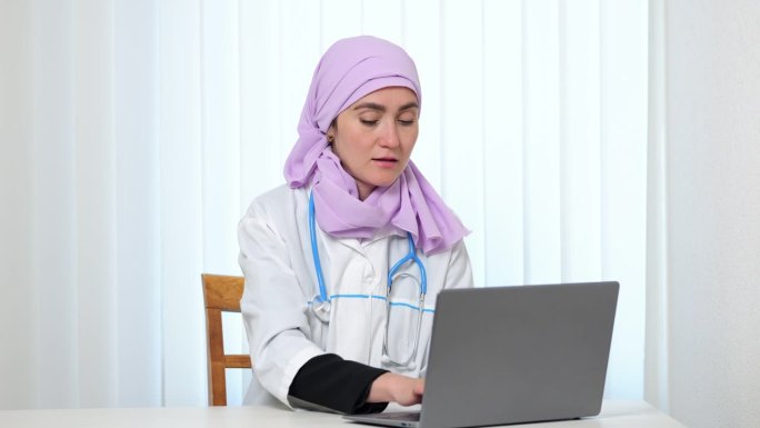 戴着粉色头巾的穆斯林医生在私人诊所工作