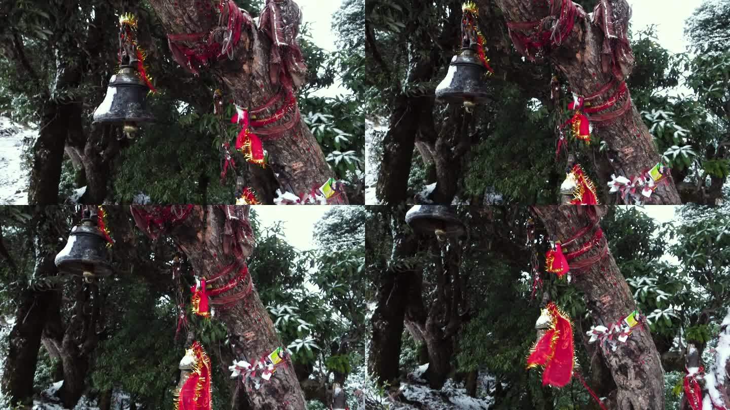 电影慢动作镜头，挂着神圣的红布的钟，背景是白雪覆盖的山脉，印度北阿坎德邦的鲁德拉普拉亚的Kartik