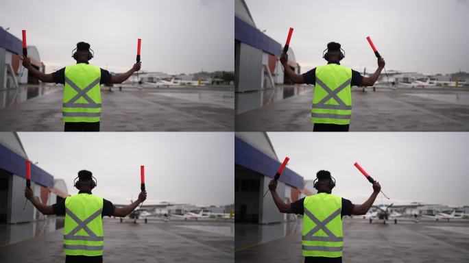 一个人在机场用指挥棒给飞行员发信号