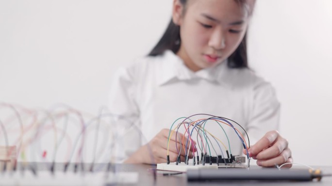 女学生在教室里组装机器人