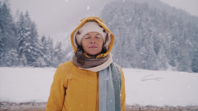 女人在冬日的雪景中享受着新鲜的空气